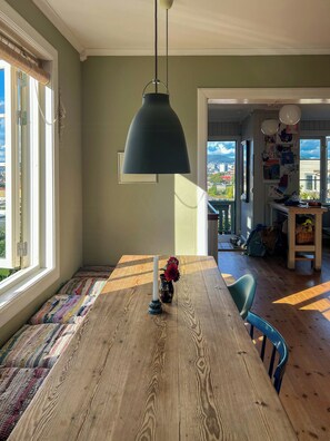 A dining area with a wooden table, a candle, and a vase with flowers. - Listed terraced house with views over Oslo centre (Oslo)