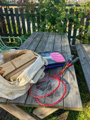 A wooden picnic table with a badminton racket, a blue bag, and a cloth bag with items. - Listed terraced house with views over Oslo centre (Oslo)