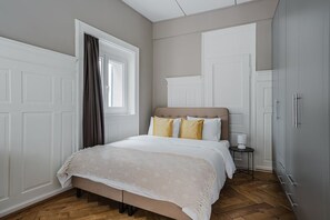 Een slaapkamer met een bed, nachtkastje, en een kledingkast.
