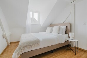 A bedroom with a bed, bedside table, and a window. - Bright 4.5-room apartment in Kreis 6, roof terrace, near ETH (Zürich)