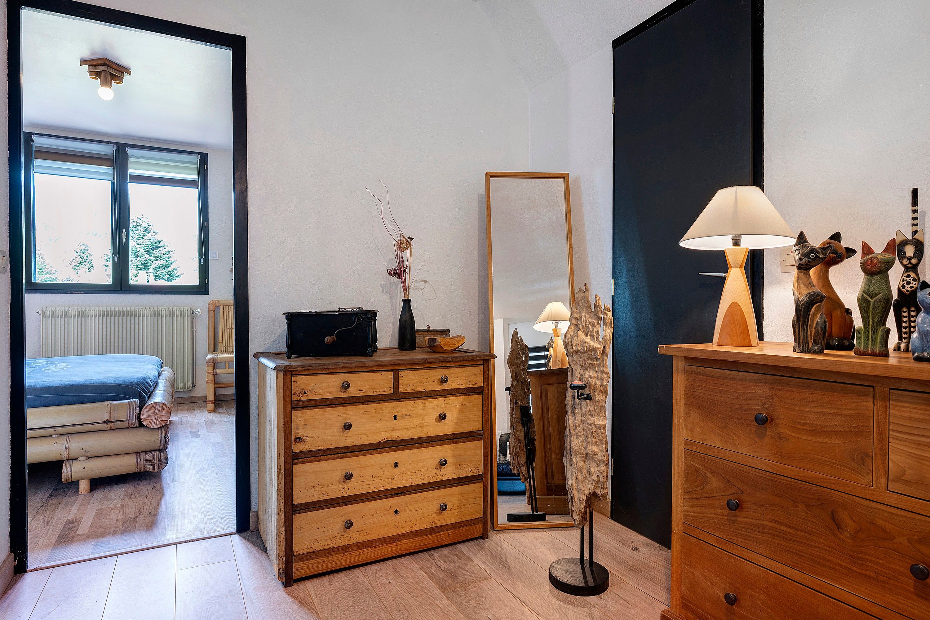 Quarto com cama, cômoda, espelho e abajur.