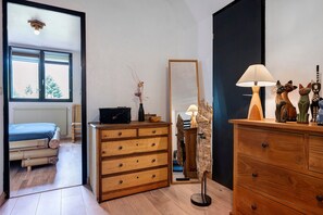 A room with a bed, a dresser, a mirror, and a lamp.
