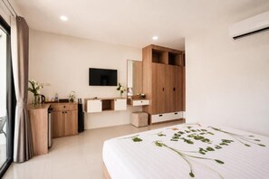 Una camera da letto moderna con un letto, un armadio in legno, una TV a schermo piatto e un comodino con un vaso.