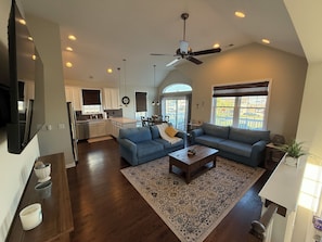 A spacious living room with a large sectional sofa, a coffee table, and a ceiling fan. - Coastal Dream at Ortley Beach (Seaside Heights)