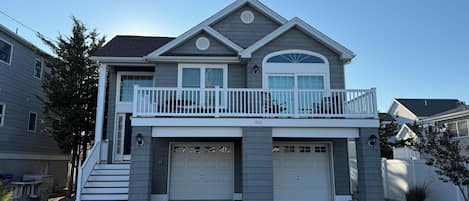 Une maison à deux étages avec un balcon, un garage et une allée.