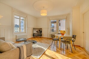 Uma sala de estar ampla com sofá, mesa de centro e área de jantar com cadeiras e mesa.