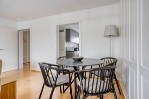 Ein Essbereich mit einem runden Tisch, vier Stühlen und einer Lampe.