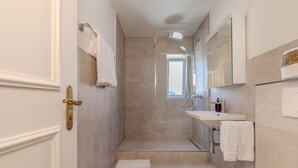 Un baño moderno con ducha, lavabo e inodoro.