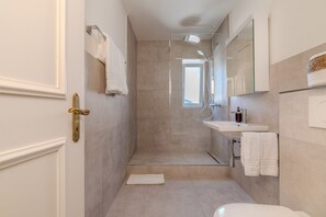Ein modernes Badezimmer mit Dusche, Waschbecken und Toilette.