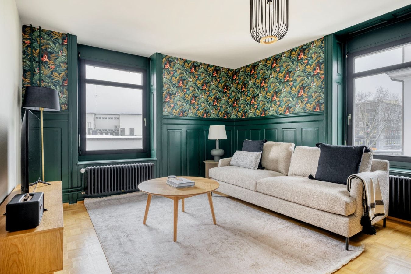 A living room with a sofa, a coffee table, a lamp, and a radiator.