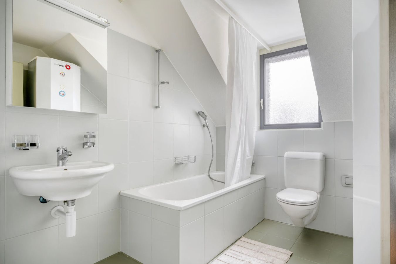 A modern bathroom with a bathtub, a toilet, and a sink.