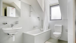 Un bagno moderno con una vasca, un water e un lavandino.