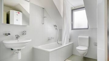 A modern bathroom with a bathtub, a toilet, and a sink.