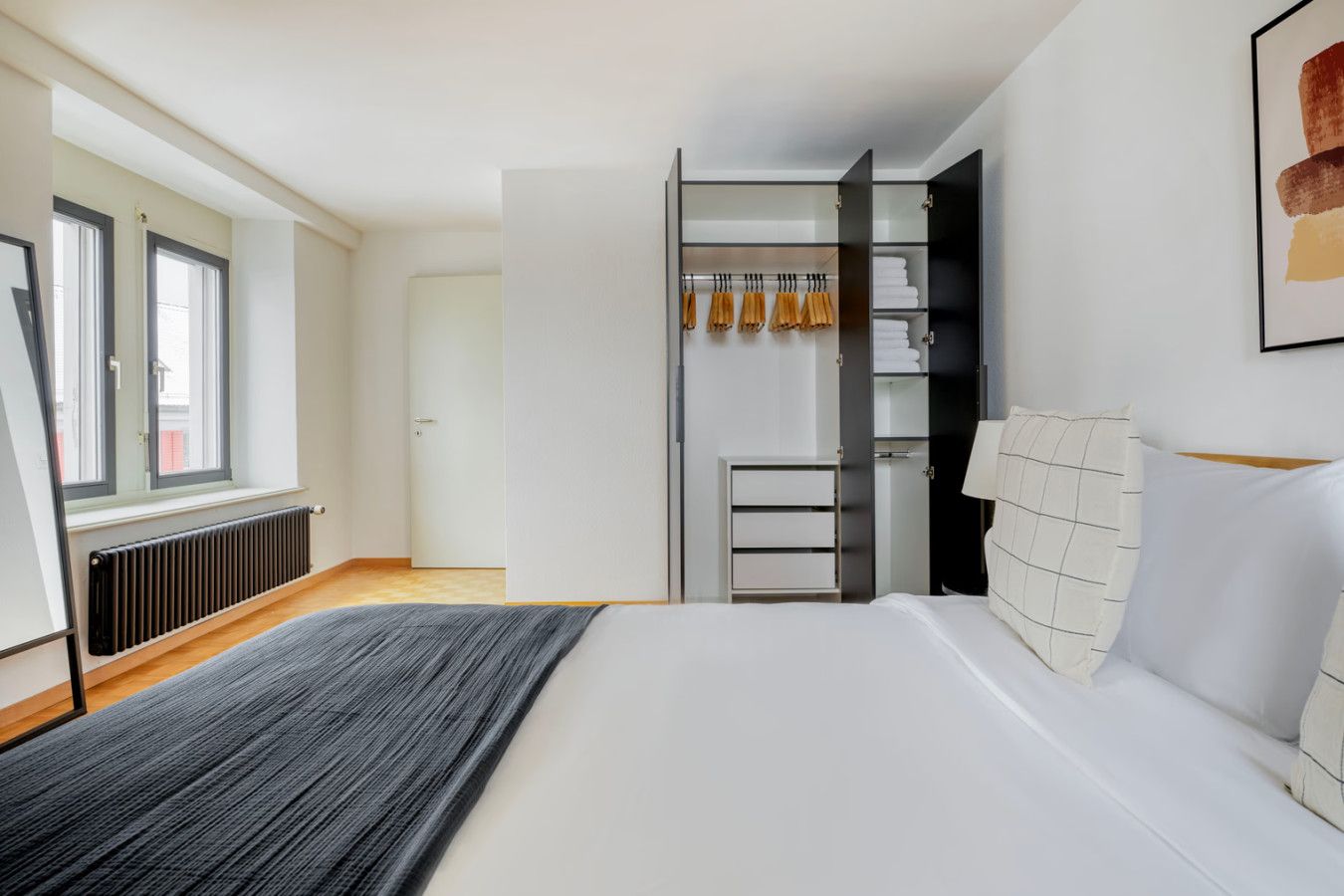 A bedroom with a bed, a wardrobe, and a radiator.