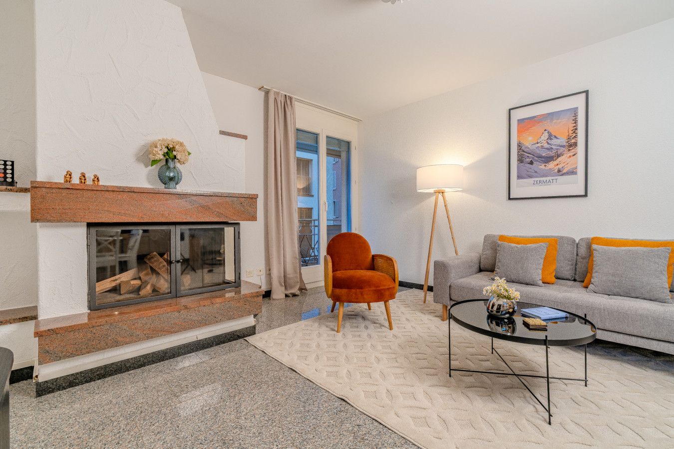 Un salon avec une cheminée, un canapé, une table basse et un tableau au mur.