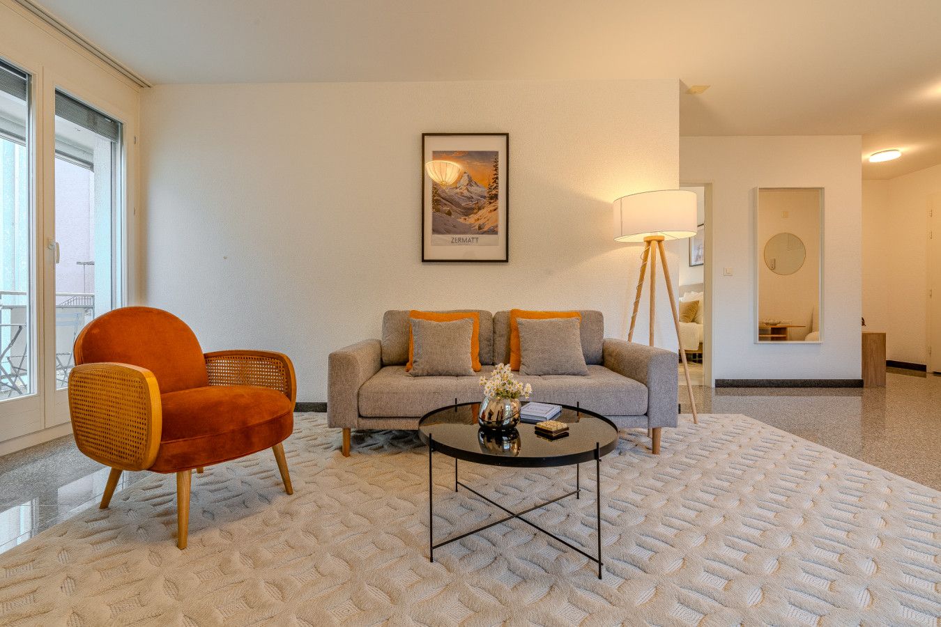 A modern living room with a sofa, a chair, a coffee table, and a floor lamp.