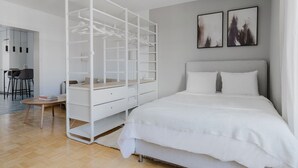 Une chambre à coucher avec un lit, une armoire blanche, un bureau et une chaise.