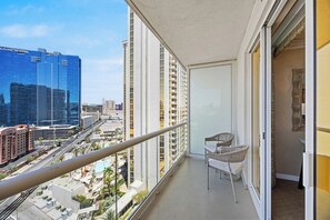 Ein Balkon mit Blick auf eine Stadtlandschaft, darunter ein Hotel und Hochhäuser.
