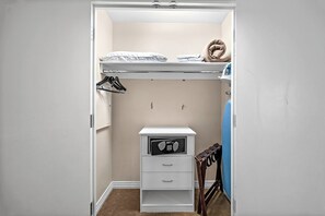 Ein gemütliches Schlafzimmer mit Etagenbett, einem kleinen Schreibtisch mit Radio und einem Sessel.