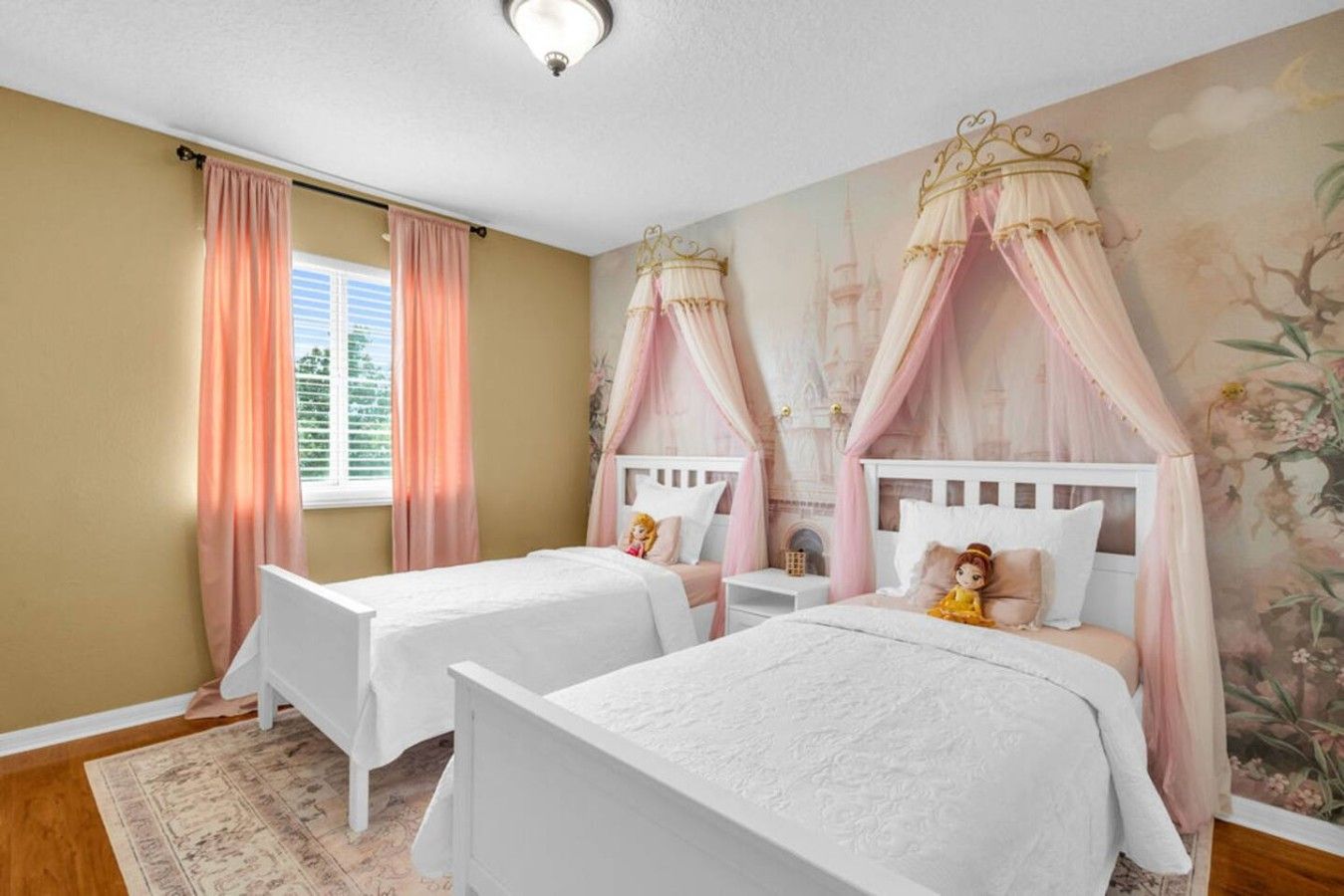 A bedroom with two beds, each with a canopy, a window with curtains, and a floral wall mural.