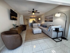 A modern living room with a sectional sofa, a brown leather chair, a coffee table, and a floor lamp. - Waterfront condo with sun deck and easy access to beaches & dining. (Englewood)
