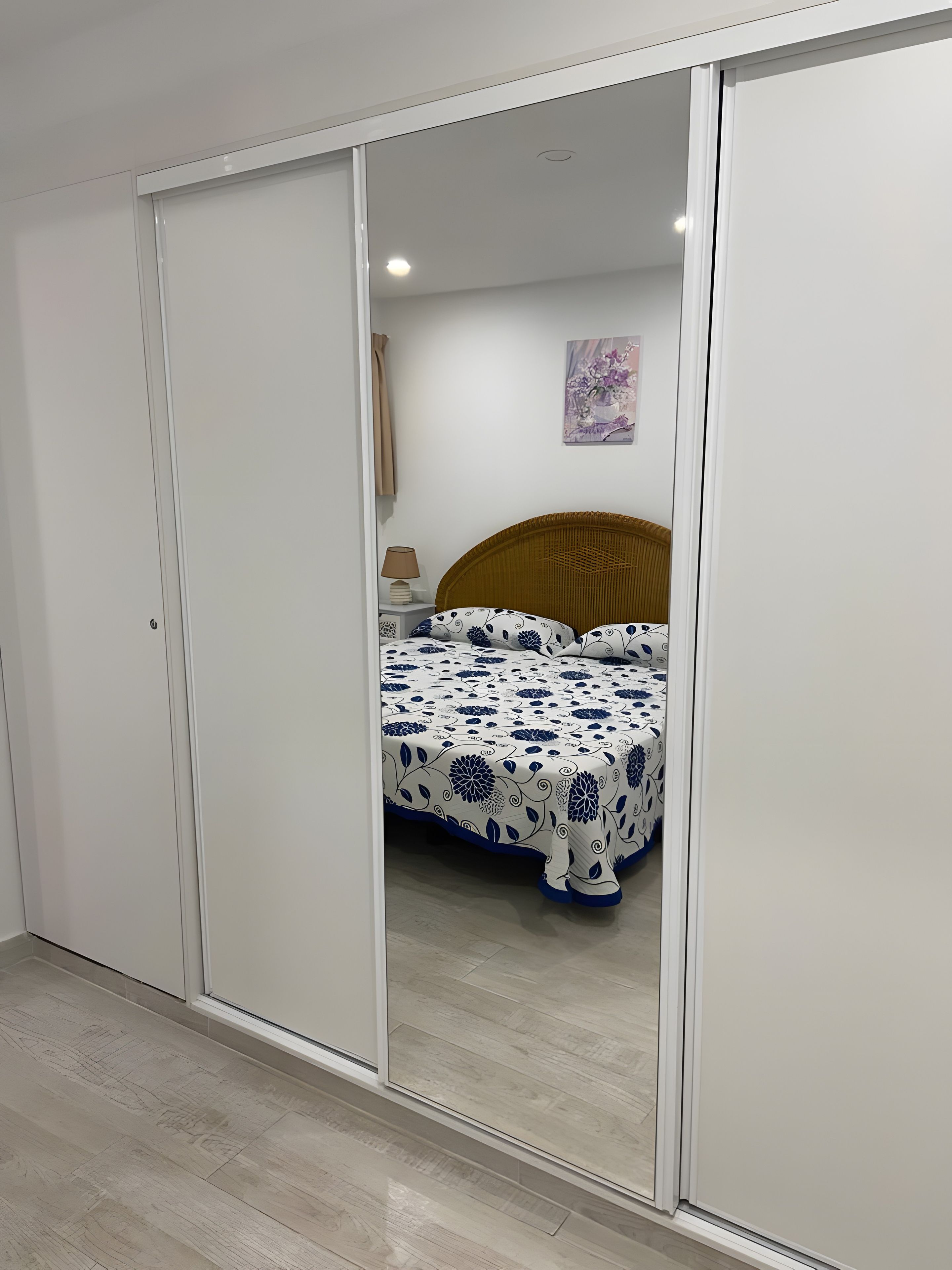 Une chambre à coucher avec un lit, une table de chevet, une lampe et un tableau au mur.