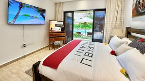 Ein Hotelzimmer mit einem Bett, einem Schreibtisch, einem Fernseher und Blick ins Freie.