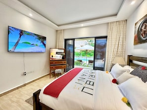 Ein Hotelzimmer mit einem Bett, einem Schreibtisch, einem Fernseher und Blick ins Freie.