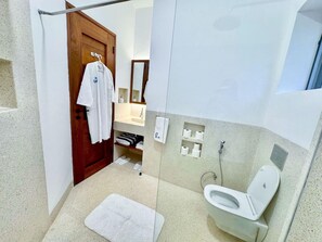 Ein Badezimmer mit Toilette, Dusche und Handtuchhalter.