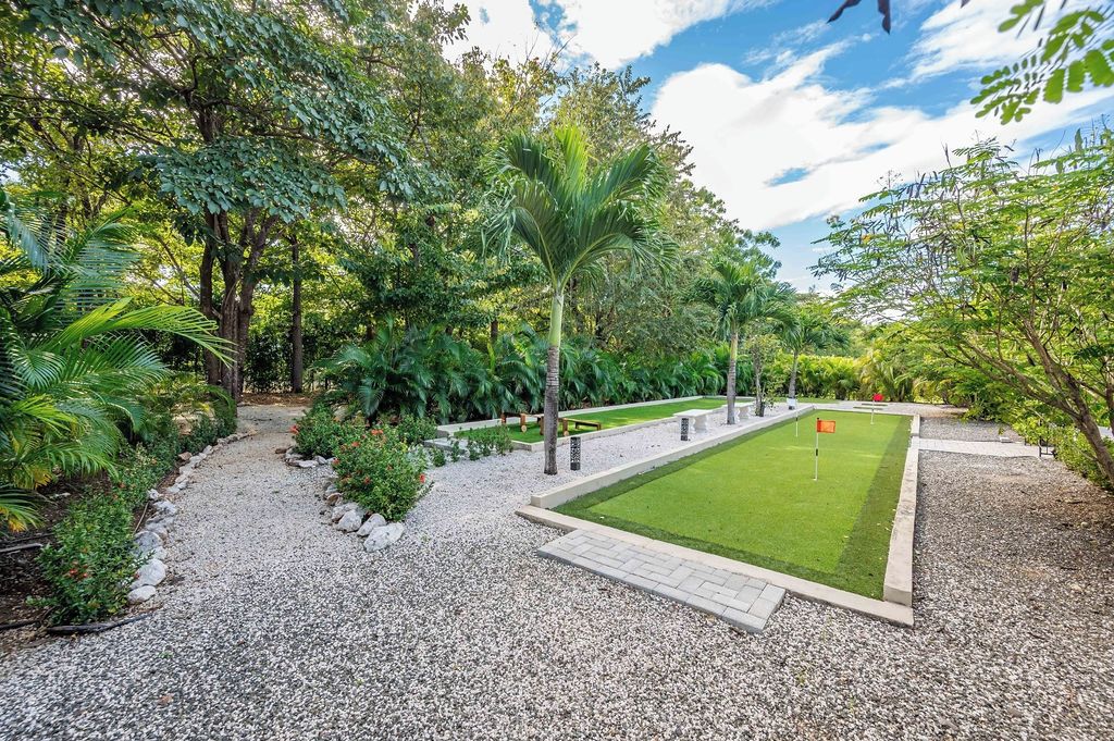 Un jardín bien cuidado con un sendero de grava, césped recién cortado y diversas arbustos y árboles.