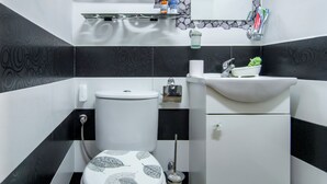 Une salle de bain avec des toilettes, un lavabo et un miroir.
