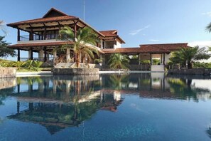 A two-story building with a pool in front. - Casa Solara | Hacienda Pinilla (Hacienda Pinilla)