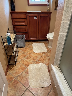A bathroom with a wooden vanity, a toilet, a shower area, and a tiled floor. - Private, Stylish Studio w/ Separate Entrance—Spacious, Serene & Comfortable (Oakland)