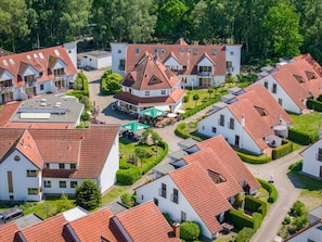 Ein Wohngebiet mit mehreren Häusern, jedes mit roten Ziegeldächern und weißen Fassaden.