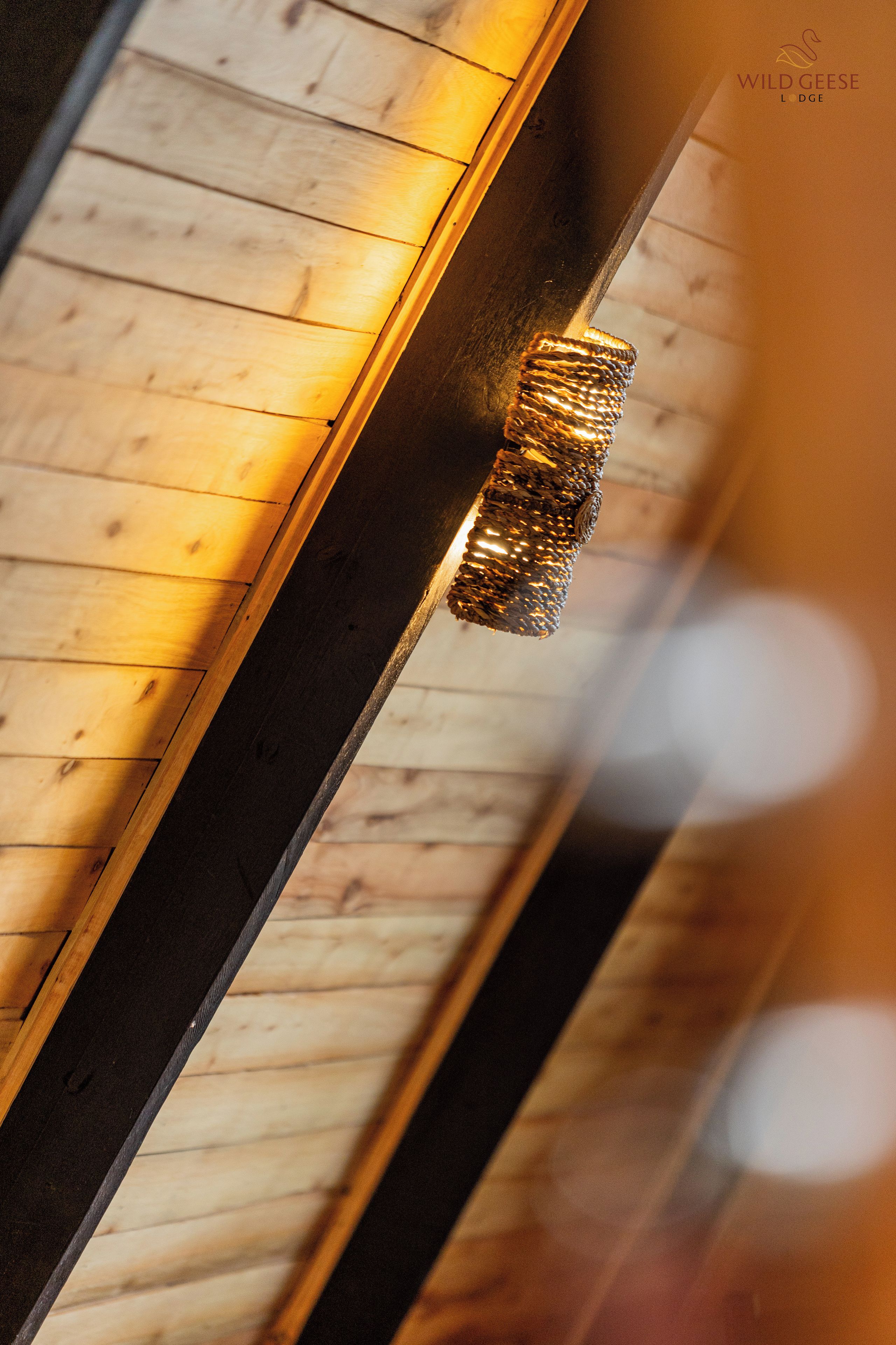 A wooden ceiling with a hanging light fixture.