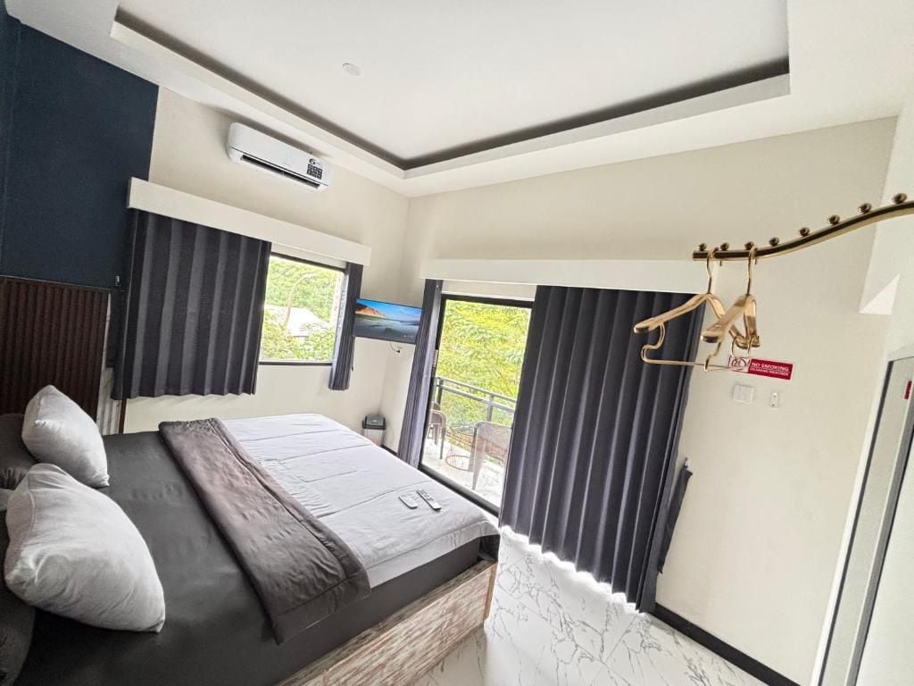 A bedroom with a bed, a window, and an air conditioning unit.
