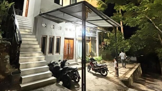 A modern two-story building with a covered entrance and a staircase leading to the upper level. - Hostel Labuan ORA (Labuan bajo)