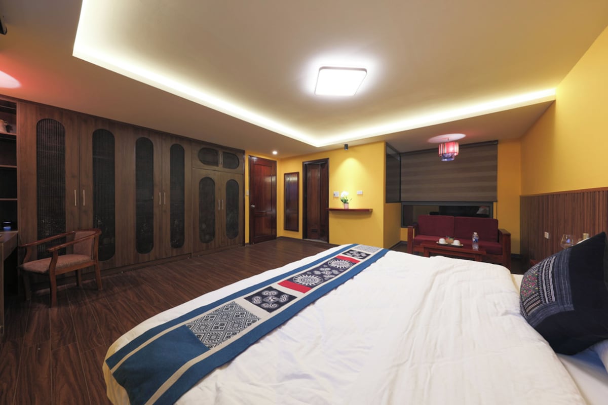 Een hotelkamer met een groot bed, een bureau, een stoel en een bank.