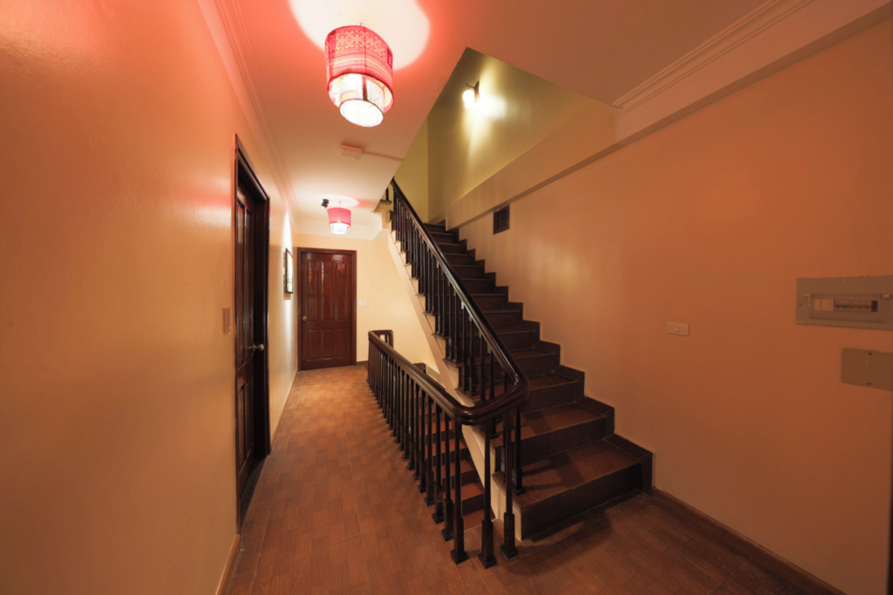 A staircase with wooden steps and a black handrail leading to an upper floor.
