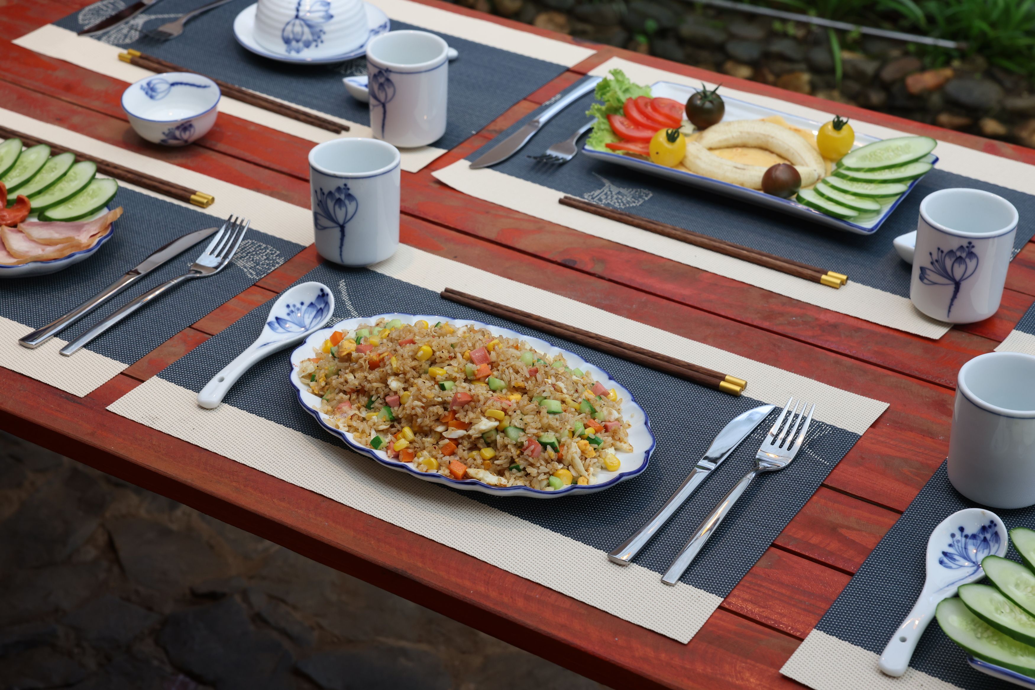 A table set with a plate of fried rice, a bowl of soup, and various side dishes.