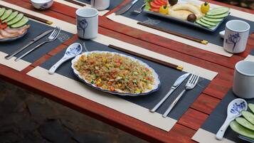 A table set with a plate of fried rice, a bowl of soup, and various side dishes.