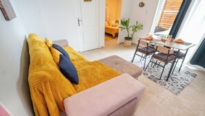 Una camera accogliente con un letto, un tavolino con una pianta e un'area pranzo con sedie.