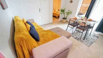 Une pièce confortable avec un lit, une petite table agrémentée d’une plante et une vue sur un balcon.