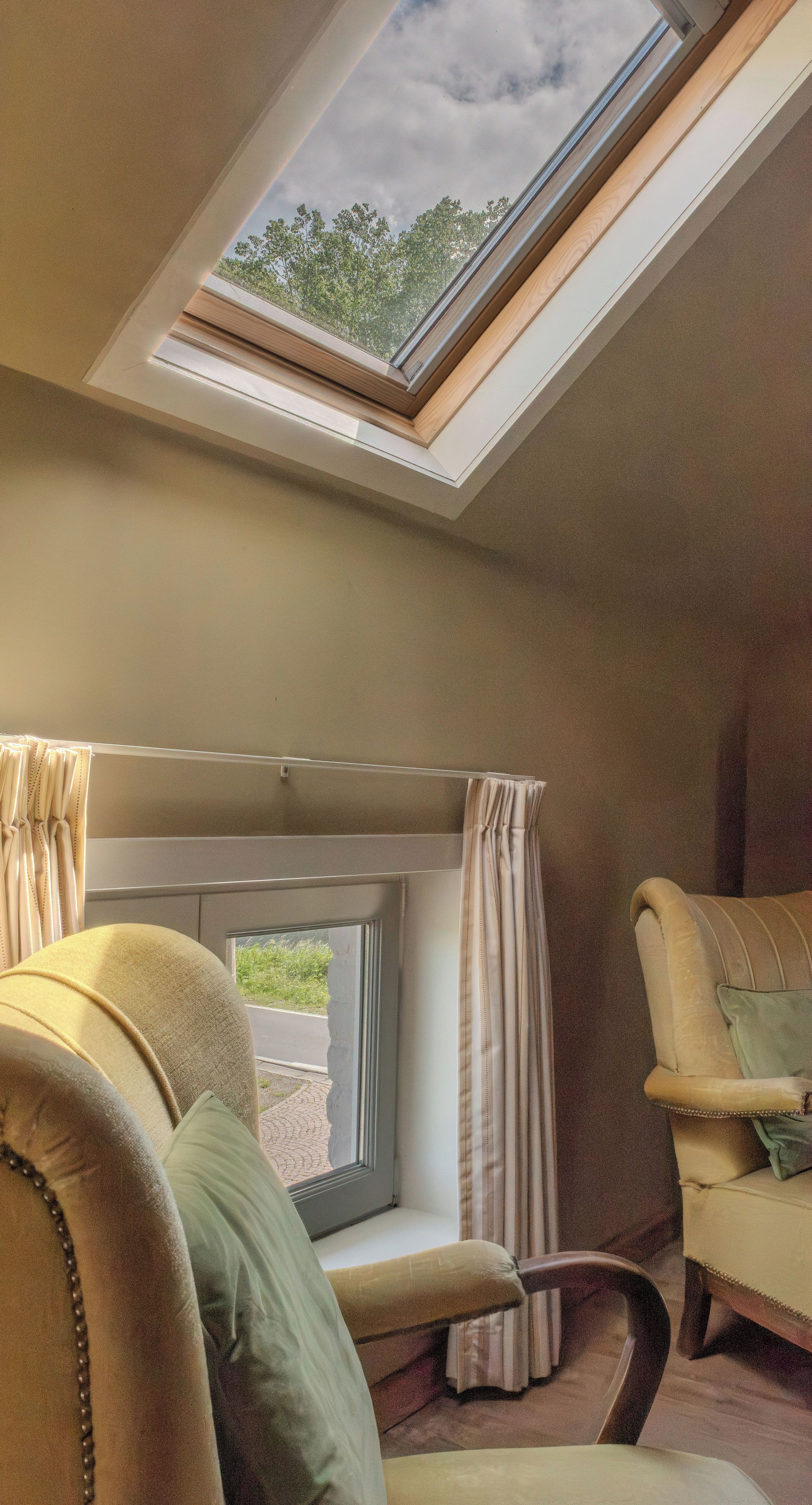 Ein Zimmer mit Oberlicht, Fenster und zwei Stühlen.