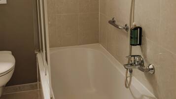 A bathroom with a bathtub, a shower, and a toilet.