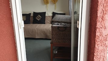 A room with a bed, a table, and a window with curtains.