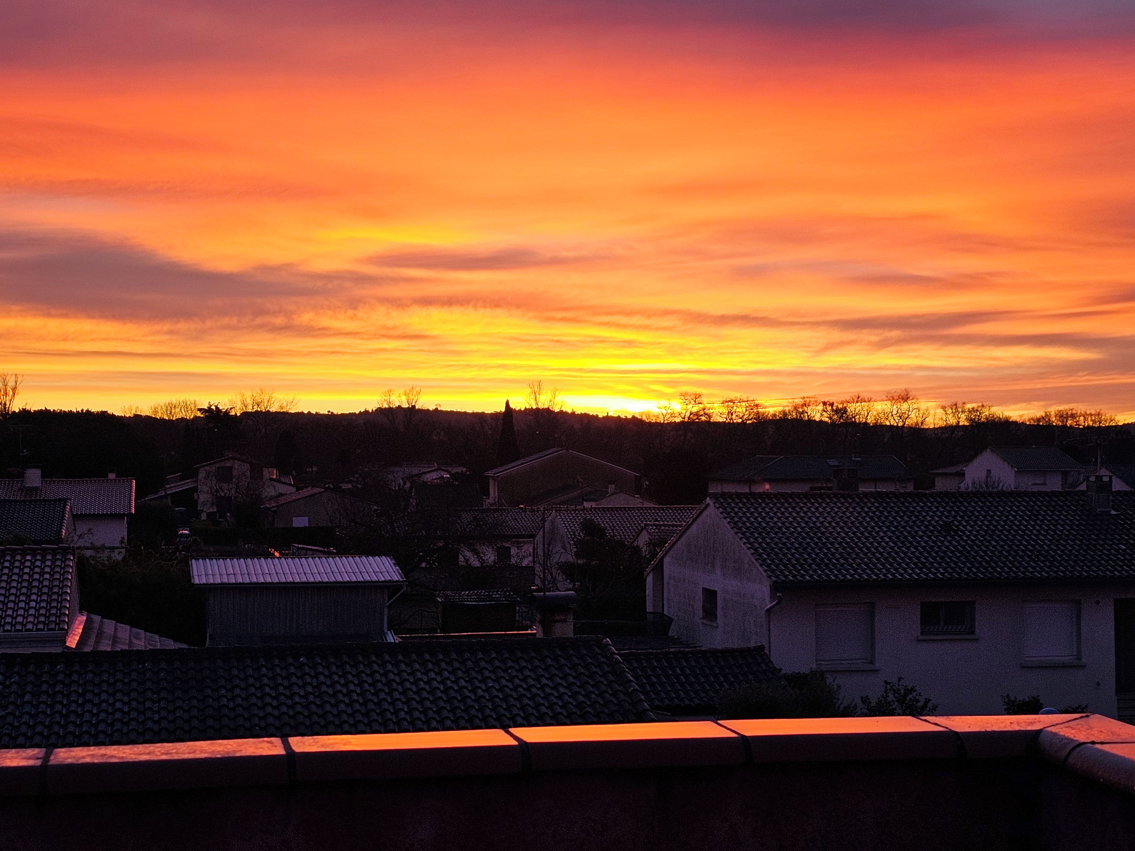 Un barrio residencial con casas y un atardecer.