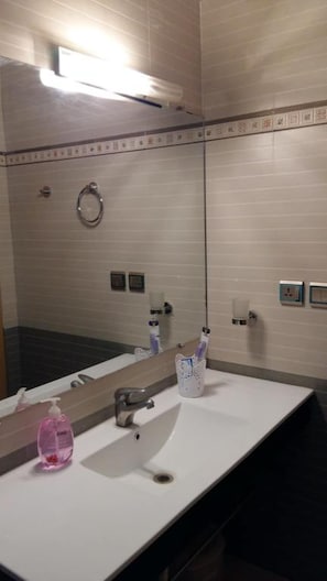 Ein Badezimmer mit Waschbecken, Spiegel und Handtuchhalter.
