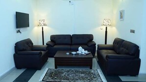 Una sala de estar con un sofá, una mesa de centro y dos lámparas.