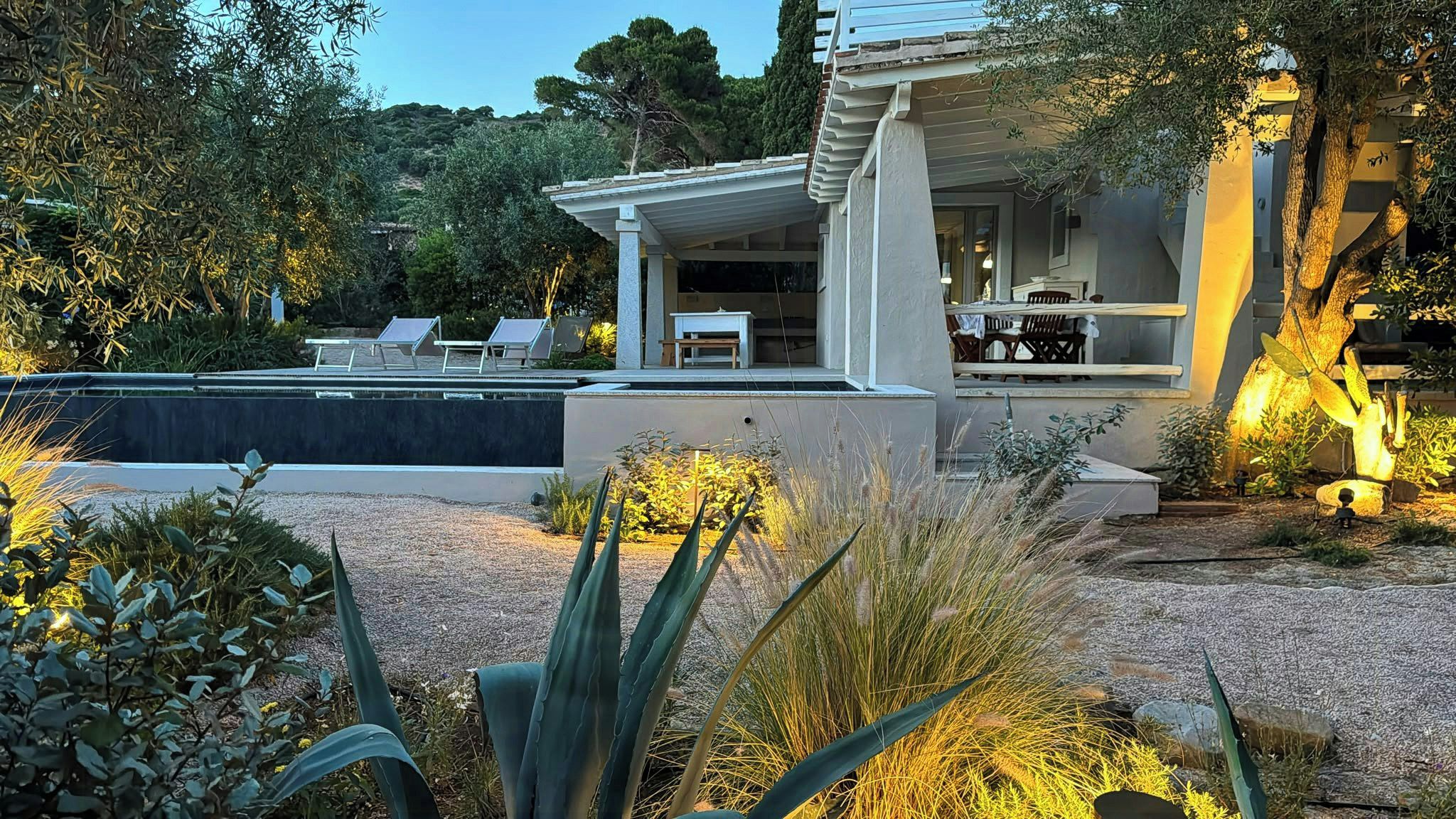 A modern house with a swimming pool, outdoor seating, and a well-maintained garden.